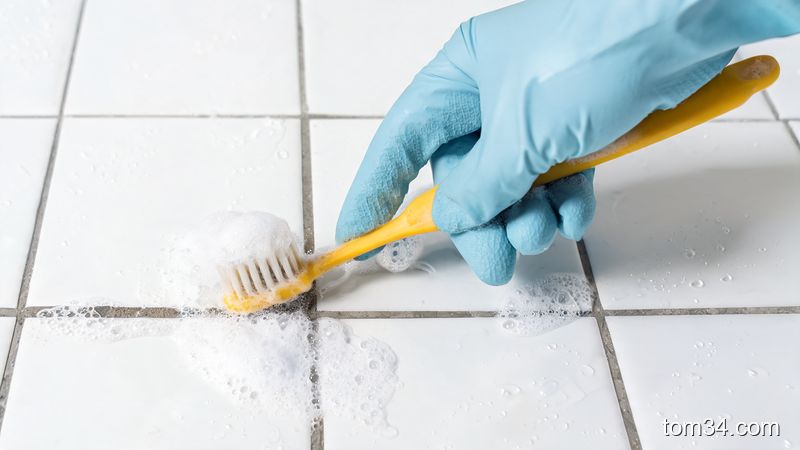 用小苏打和白醋混合后刷洗瓷砖缝隙的特写