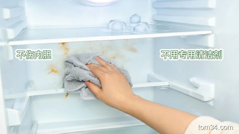清新明亮居家冰箱内部场景,手拿着沾了小苏打水的软布擦拭冰箱内胆油污,旁边是自然融化的小冰块,画面标注“不伤内胆”“不用专用清洁剂”文字,突出安全方便